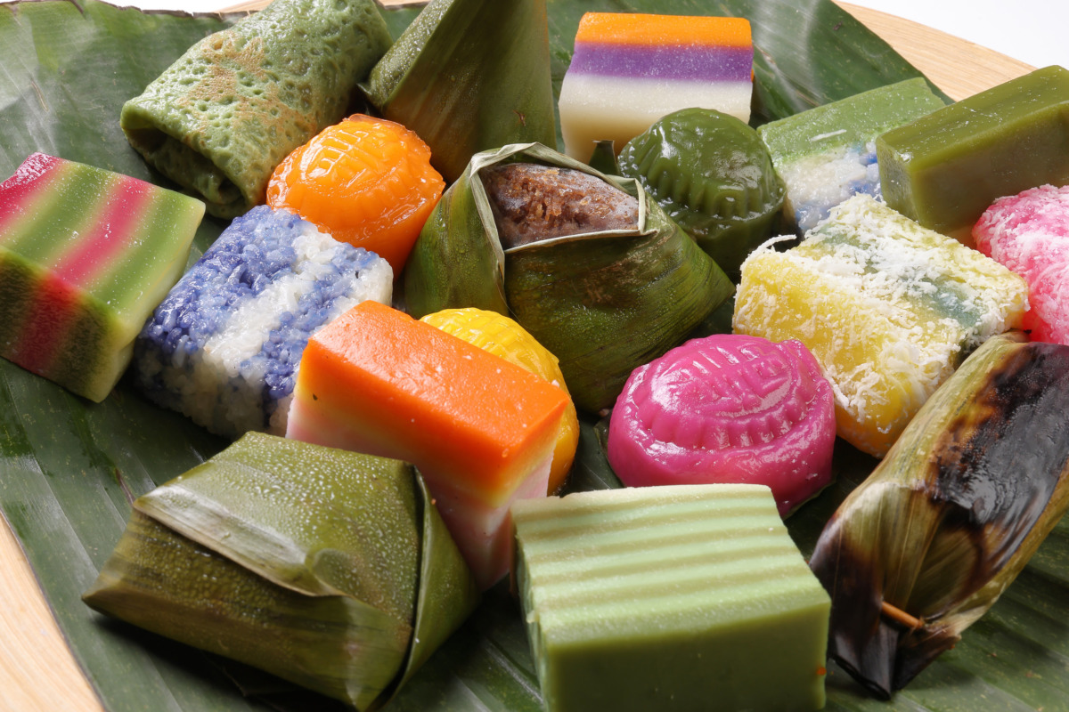 Varity Malaysian south east Asian nyonya kuih sweet desert sago tilam pulut terkan inti koci bongkus koo lapis dodol onde onde on green banana leaf wooden plate